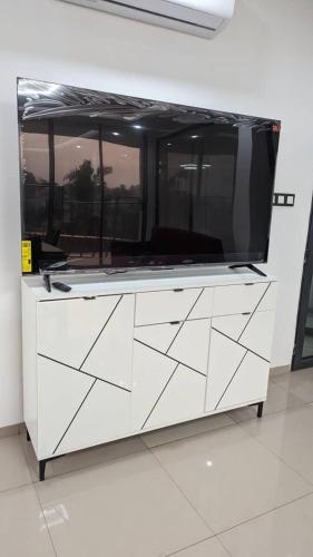 a large white dresser with a tv on top of it at Villa Victoria Résidence in Lomé