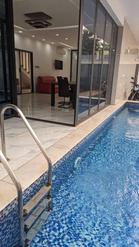 a large swimming pool in a building with a room at Villa Victoria Résidence in Lomé
