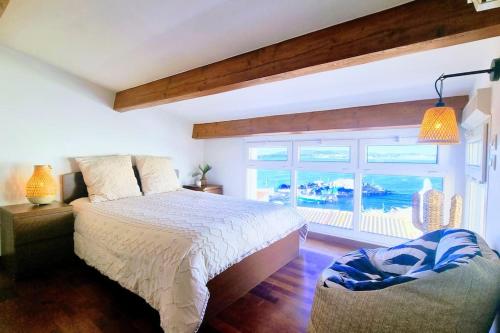 une chambre avec un lit et une grande fenêtre dans l'établissement LE BARREUR Maison Authentique Sètoise La pointe Courte, Bord de Mer, Climatisée, Parking gratuit proximité, à Sète