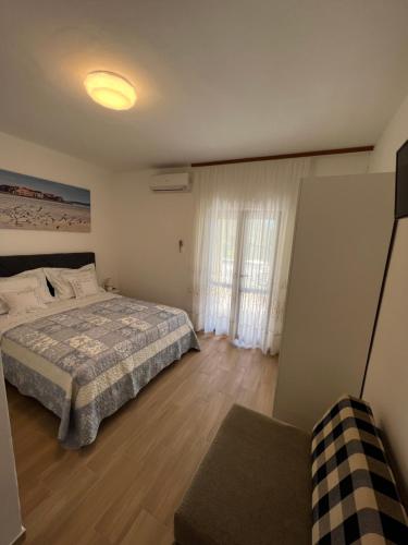 a bedroom with a bed and a window and a couch at Lisica in Bibinje