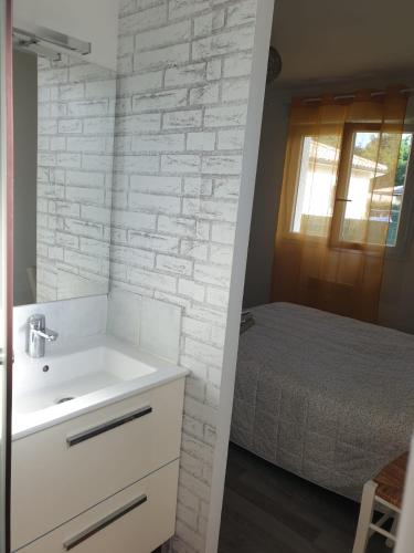 - une salle de bains blanche pourvue d'un lavabo et d'un lit dans l'établissement Villa familiale Bassin Arcachon, à Salles