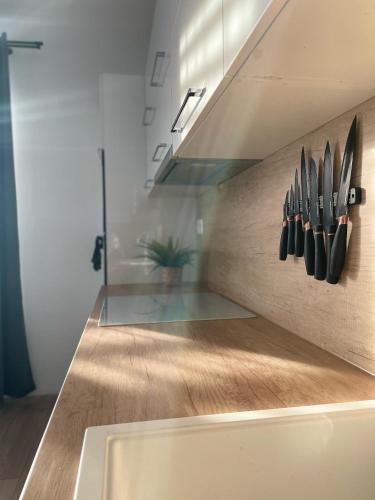 Klimatizovaný Apartmánový dom, s vírivkou, 1B في سينيتش: مطبخ مع سكاكين معلقة على الحائط