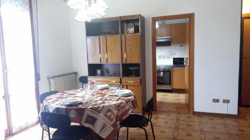 a dining room with a table and a kitchen at Casa Luciano Bellaria Centro in Bellaria-Igea Marina
