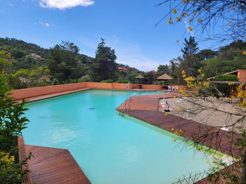 une grande piscine avec une terrasse en bois dans l'établissement Appartement au cœur des Albères, au Boulou