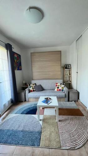 un salon avec un canapé et une table dans l'établissement Green Studio - Au cœur du Golf, à Mouans-Sartoux