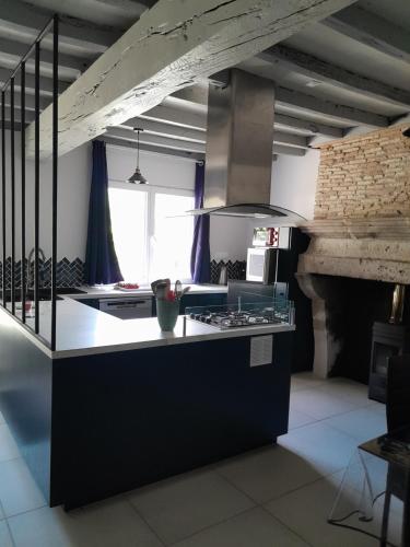 a kitchen with a counter and a stove top oven at maison de campagne rénovée in Duras