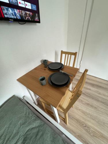 a wooden table with a chair and a tv at Günstiges Apartment Gelsenkirchen Schalke in Gelsenkirchen
