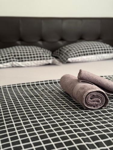 two rolled towels sitting on top of a bed at SUNRAY Apartman Požarevac in Požarevac