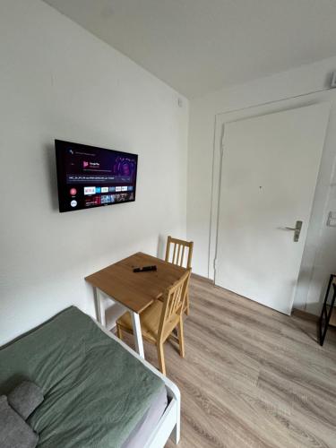 a bedroom with a bed and a table and a tv at Günstiges Apartment Gelsenkirchen Schalke in Gelsenkirchen