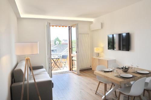 ein Wohnzimmer mit einem Tisch und Stühlen sowie ein Esszimmer in der Unterkunft Gold Garda Desenzano in Desenzano del Garda