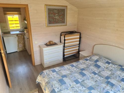 1 dormitorio pequeño con 1 cama y cocina en Ramybės kampelis, en Šventoji