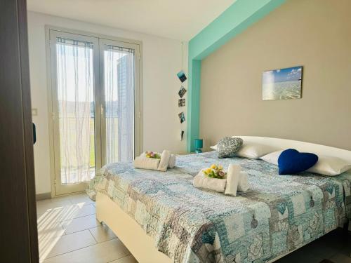 Mansarde Marzamemi في مارزاميمي: غرفة نوم بها سرير كبير وعليه زهور