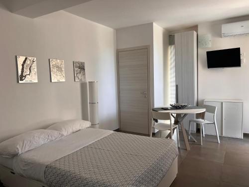 a bedroom with a bed and a table and a television at 18 Gradi Apartments in Marsala