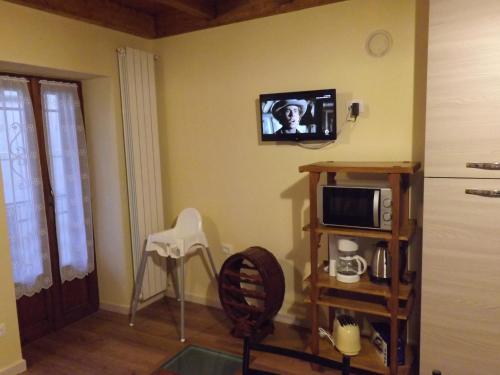 un soggiorno con forno a microonde e TV a parete di CASA INES a Stresa