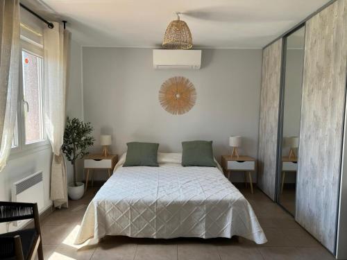 - une chambre blanche avec un lit et deux tables dans l'établissement Maison de vacances plein de charme avec piscine, à Mirepeisset