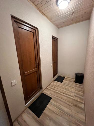 an empty room with a wooden door and wooden floors at Martha Guest House in Becho