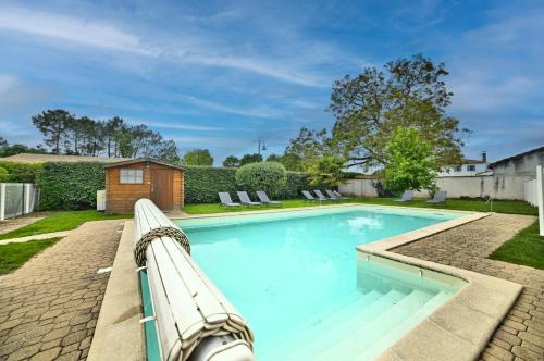 a swimming pool with a bench in a yard at Le Fief des Roses in Les Mathes