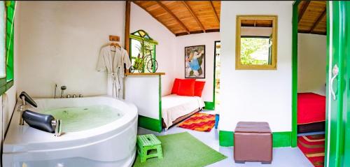 a bathroom with a tub and a bedroom with a bed at Kantarrana Casa de Campo in Jardin