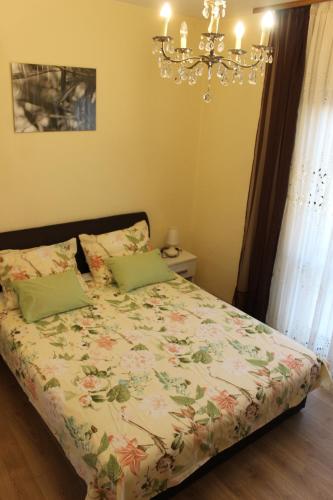 a bedroom with a bed with a floral comforter at Lisica in Bibinje
