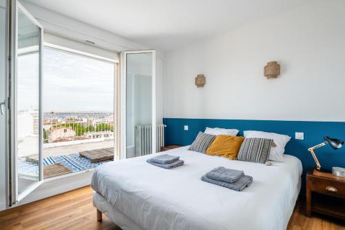 une chambre avec un grand lit et une grande fenêtre dans l'établissement Apartment with Large Terrace and Panoramic View - 2 Bedrooms, Marseille, à Marseille