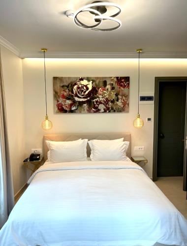a bedroom with a large white bed with two pillows at Aesthesis Arxontiko Luxury Rooms in Mirina