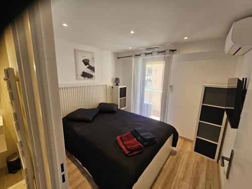 - une petite chambre avec un lit noir et une fenêtre dans l'établissement Beautiful 1 bedroom flat, à Nice