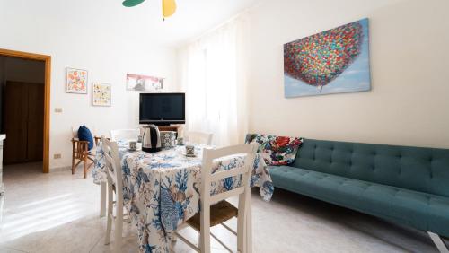 - un salon avec une table et un canapé vert dans l'établissement Casa Sole, à Favignana