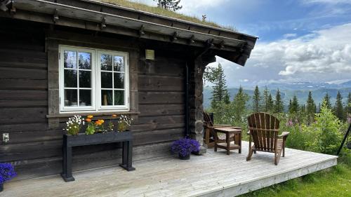 eine Hütte mit 2 Stühlen, einem Tisch und einem Fenster in der Unterkunft Liaplassen Fjellhytte in Beitostøl