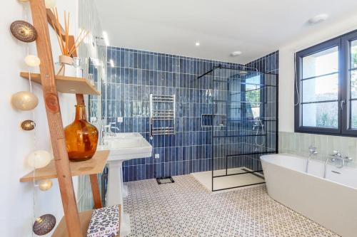 une salle de bain avec une baignoire et un lavabo et une baignoire dans l'établissement Villa climatisée, Piscine, Plages 8mn à pied, à La Garde