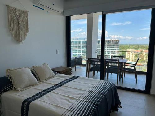 a bedroom with a bed and a dining room with a view at Aria Ocean Playa Nuevo Vallarta in Nuevo Vallarta 