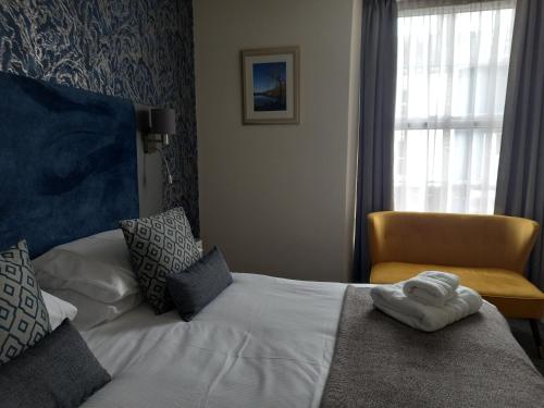a hotel room with a bed and a chair at Royal Sportsman Hotel in Porthmadog