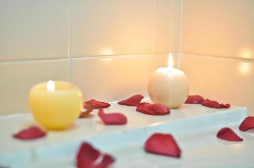 two candles and red hearts on a table at Hotel Laureles 70 Medellín in Medellín