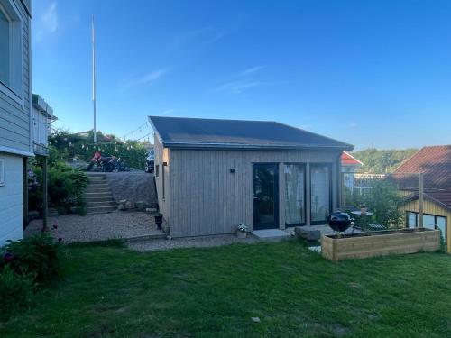 a small shed in the yard of a house at Mysigt attefallshus med närhet till stad och hav in Västra Frölunda
