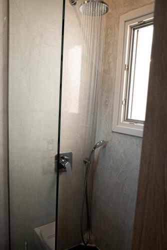 a shower stall in a bathroom with a window at Golden View Suites in Vóthon
