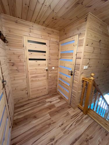 a wooden cabin with two doors and a staircase at Agroturystyka u Basi i Waldka in Zelwa