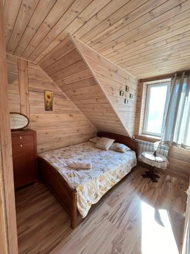 a bedroom with a bed in a wooden cabin at Agroturystyka u Basi i Waldka in Zelwa