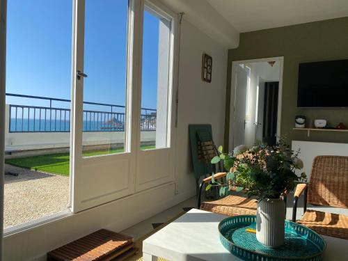 - un salon avec une table et une vue sur l'océan dans l'établissement L'appart du Val, Vue mer, à Pléneuf-Val-André