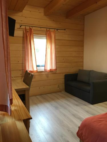 a room with a bed and a couch and a window at Rodinný penzion U Hafana a U Hospůdky in Řeka