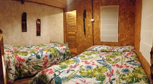 Casa de leña, cabaña rural في فيلا دي ليفا: غرفة نوم بسريرين ومرآة