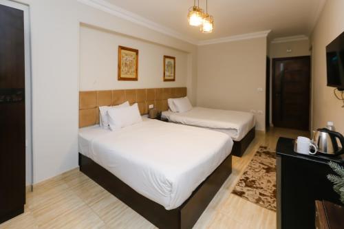 a hotel room with two beds and a television at Crowne Pyramids View inn in Cairo