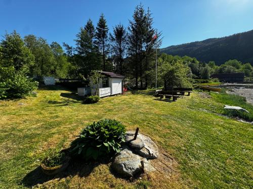a park with a building and a picnic table in the grass at Strandhytte nær preikestolen in Strand