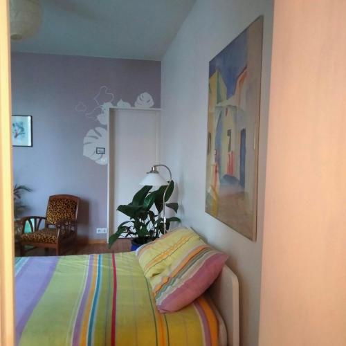 - une chambre avec un lit et une couverture colorée dans l'établissement Grand studio calme et lumineux, à Toulouse
