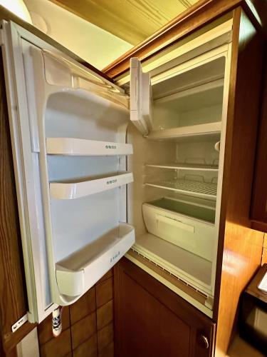an empty refrigerator with its door open in a kitchen at Ferienhaus Moßhammer in Lofer