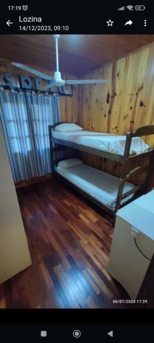 two bunk beds in a room with a wooden floor at Cabaña del rio Paraná in Puerto Iguazú