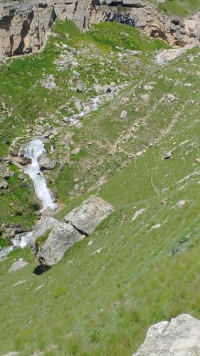 a grassy hill with a stream of water at Zaur Guest hause in Xınalıq