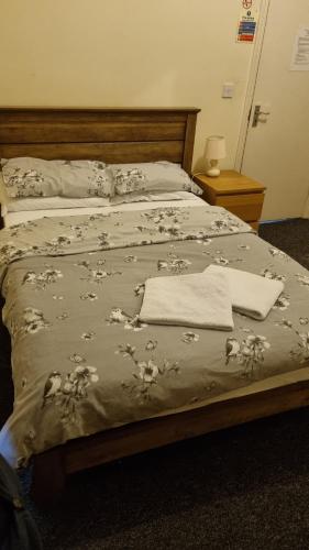 een bed met een deken en een handdoek erop bij Shamrock Guest House in Gravesend