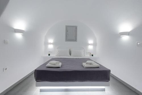 a white room with a bed with two towels on it at Golden View Suites in Vóthon