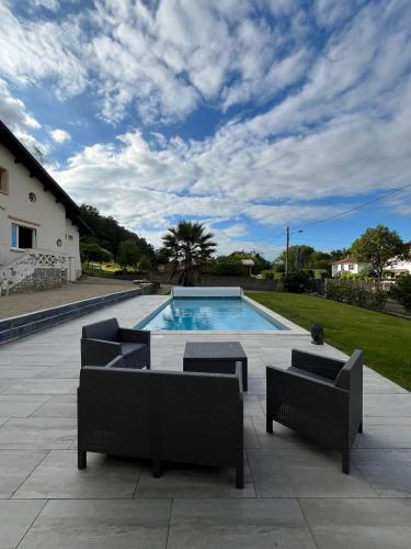- une piscine avec 2 chaises longues dans l'établissement AU PETIT CHENE, à Aire-sur-lʼAdour