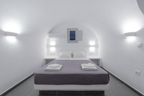 a white room with a bed with two towels on it at Golden View Suites in Vóthon