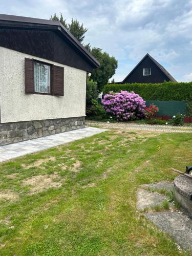 una casa con un giardino con erba e fiori di Chata na léto a Nespeky
